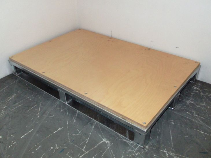 Stahlflachpalette mit Kufen und rutschhemmendem Holzdeck als Leergut im Block stapelfähig